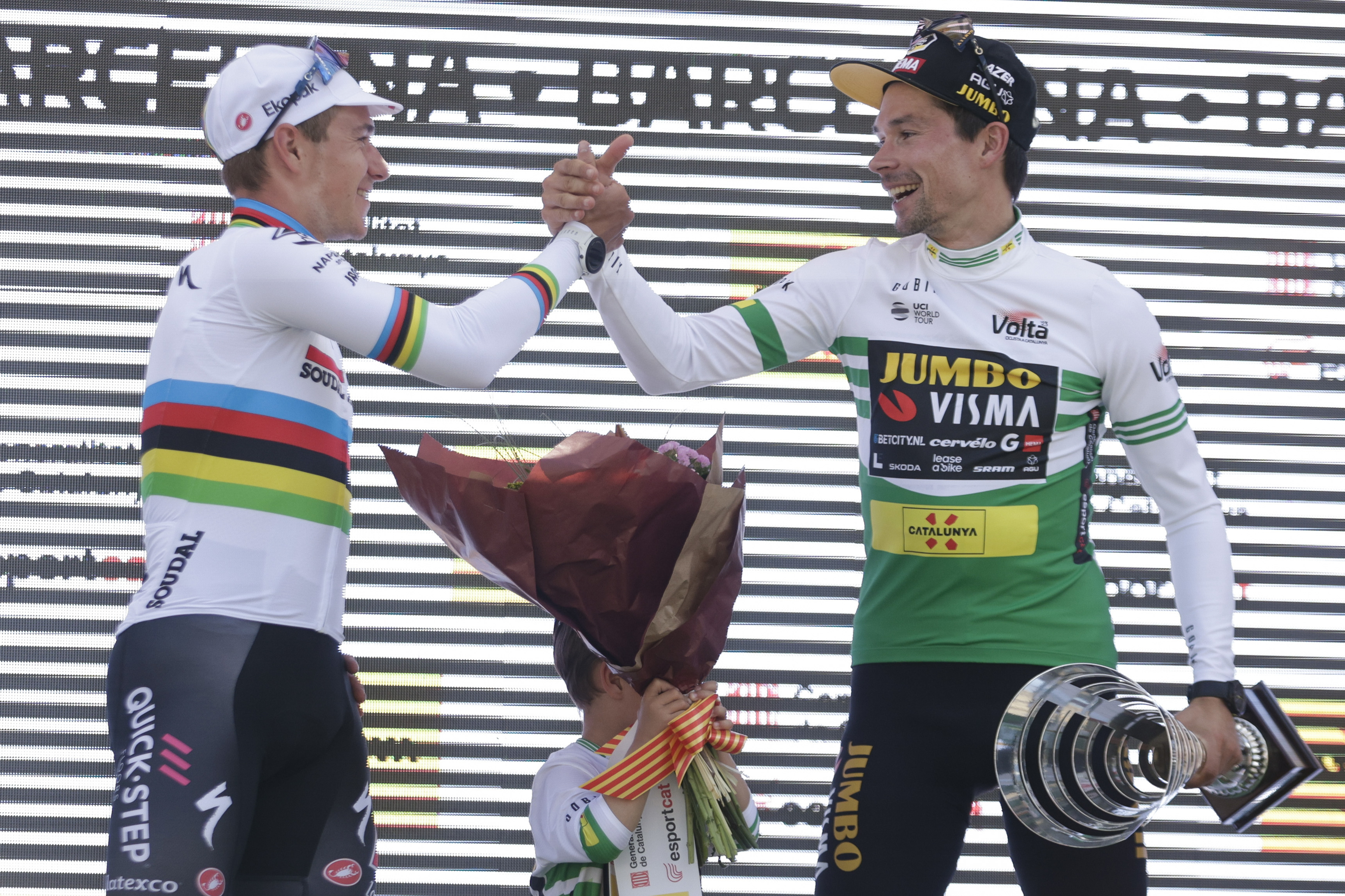 BARCELONA, 26/03/2023.- El ciclista esloveno del Jumbo -Visma, Primoz Roglic (d), celebra en el podio junto al belga Remco Evenepoel (i), segundo, tras ganar la clasificación general de la Volta Ciclista a Catalunya, con inicio y final en Barcelona, este domingo, tras disputarse la séptima y última etapa. EFE/ Quique García