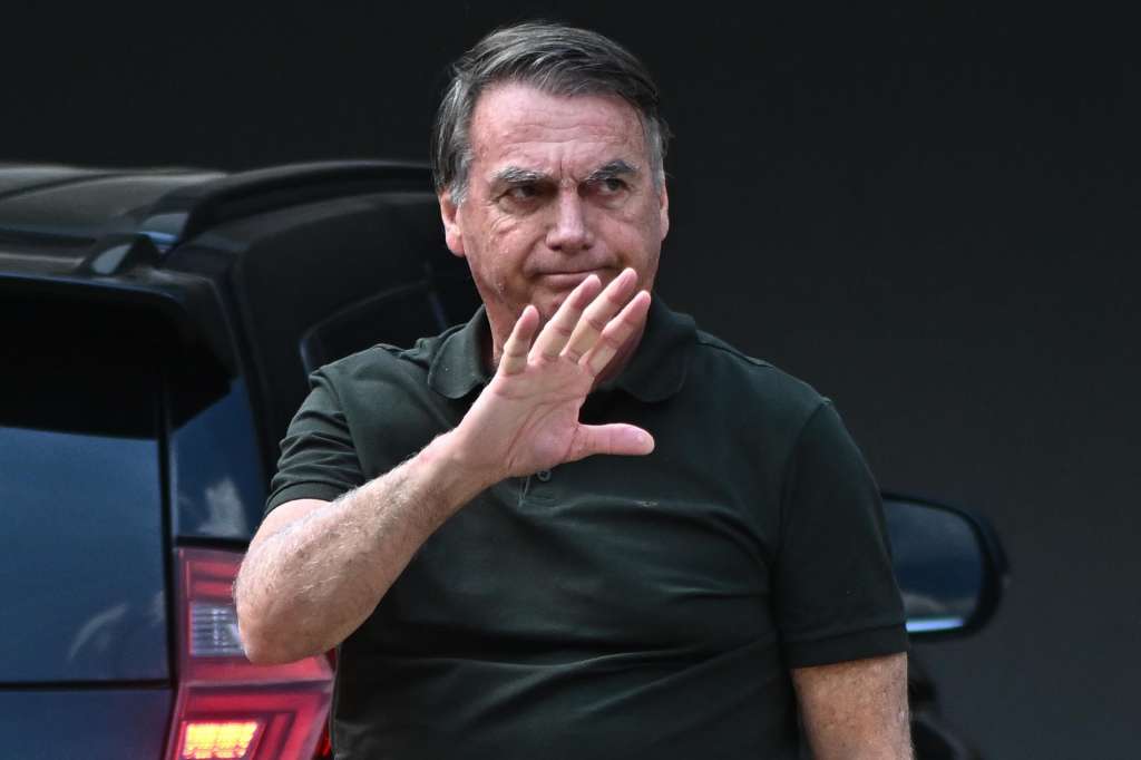 BRA50. BRASILIA (BRASIL), 14/09/2025.- El expresidente de Brasil, Jair Bolsonaro, saluda a la llegada a su casa este domingo en Brasilia (Brasil). Bolsonaro volvió a recluirse en su residencia en Brasilia siete horas después de haber ingresado en un hospital privado para una intervención quirúrgica, en la que fue su primera salida tras ser condenado a 27 años y tres meses de prisión por golpismo. EFE/Andre Borges