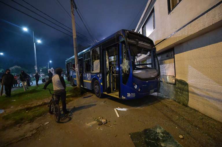 Un bus azul del SITP estrellado frente a una pared