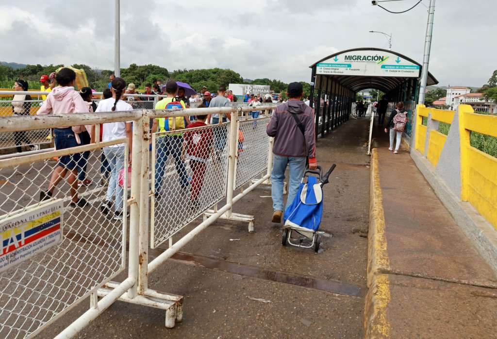 AME7398. CUCUTA (COLOMBIA), 01/12/2022.- Grupos de personas cruzan por donde antes se ubicaban los trabajadores de Migración, en el Puente Simón Bolívar, entre Colombia y Venezuela. Colombia comenzó a agilizar el paso peatonal en los puntos fronterizos con Venezuela con la reubicación de los puestos de control, que ya no estarán en la mitad de los puentes internacionales Simón Bolívar, Francisco de Paula Santander y La Unión, sino en lugares establecidos al inicio de éstos. EFE/ Mario Caicedo