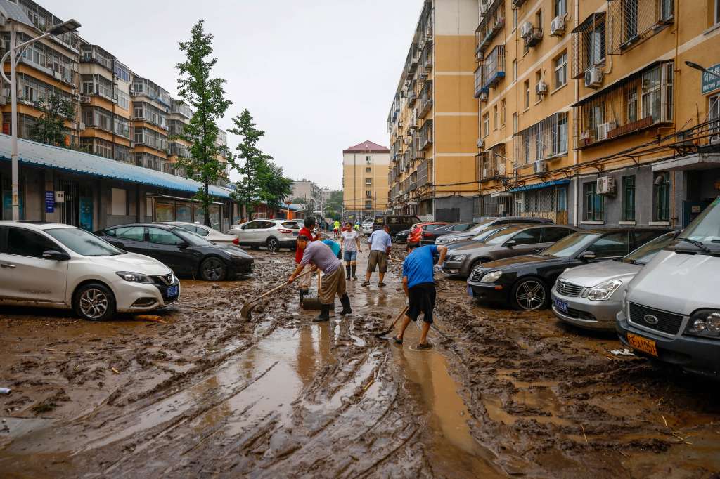 Beijing (China), 01/08/2023.- People clear a road from mud inside a residential compound in Mentougou District, west of Beijing, China, 01 August 2023. Heavy rains brought by Typhoon Doksuri caused floods in northern China and left two dead and thousands being evacuated as Beijing experienced its heaviest rainfall of the year. (Inundaciones) EFE/EPA/MARK R. CRISTINO