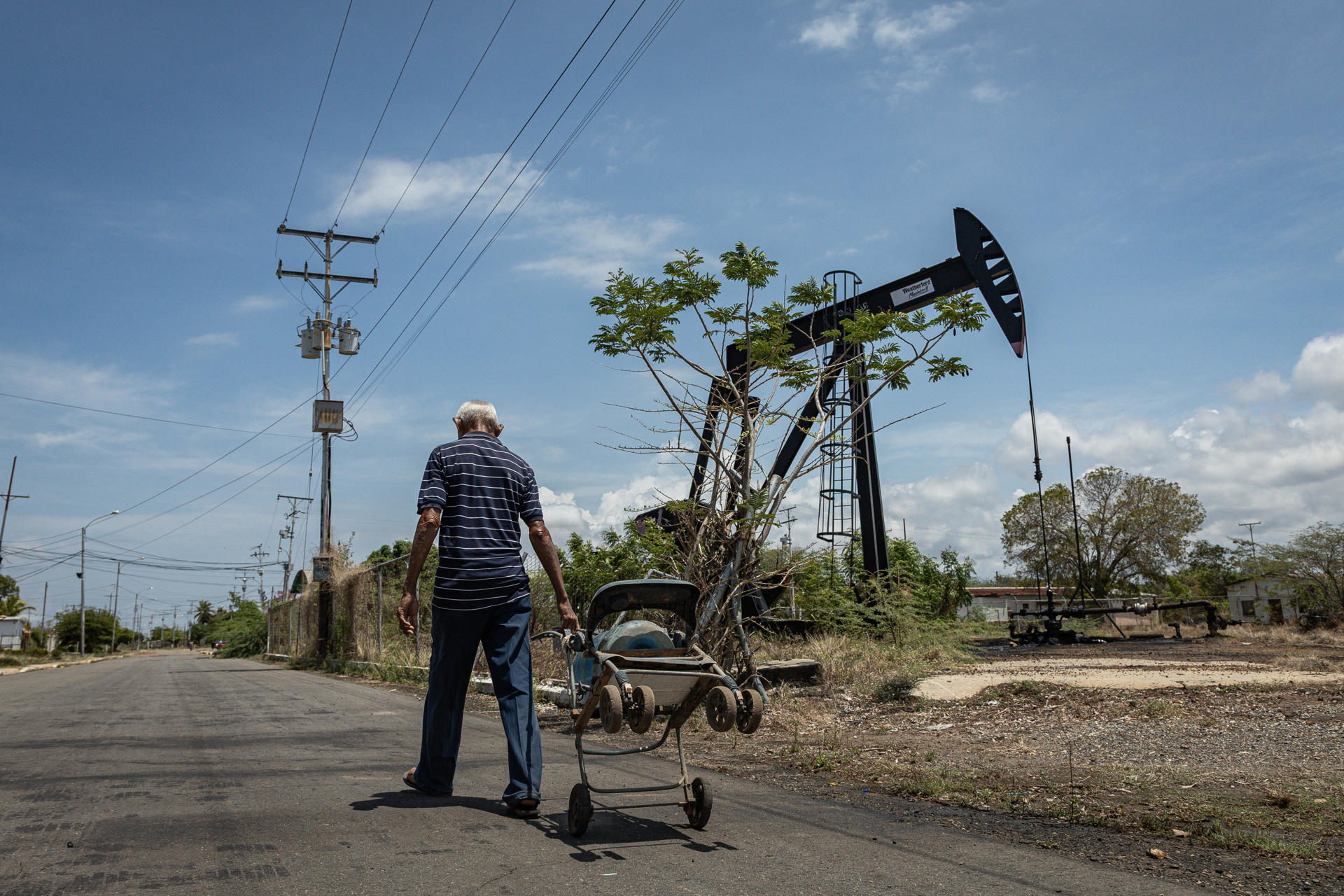 AME7177. MARACAIBO (VENEZUELA), 08/04/2025.- Un hombre camina junto a una unidad de bombeo de petróleo este martes, en Maracaibo (Venezuela). EFE/ Henry Chirinos