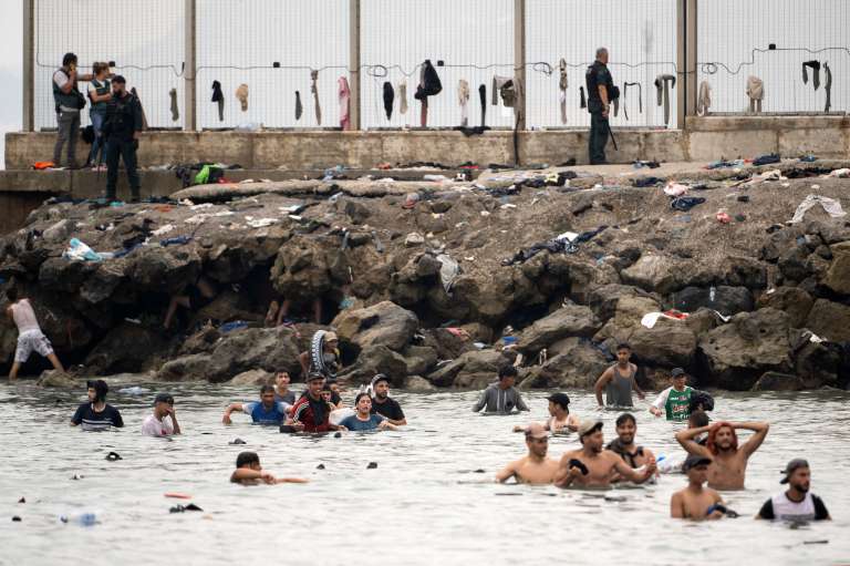 Agentes de la Guardia Civil de España vigilan la zona mientras migrantes intentan llegar nadando a través de las aguas cercanas a la frontera con Marruecos.