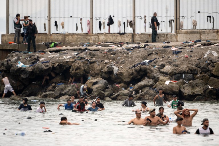 Agentes de la Guardia Civil de España vigilan la zona mientras migrantes intentan llegar nadando a través de las aguas cercanas a la frontera con Marruecos.