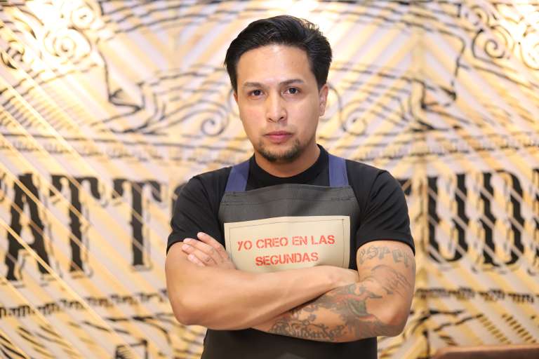 Fotografía de uno de los miembros de la Fundación Acción Interna frente al nuevo local Segundas Oportunidades Studio.