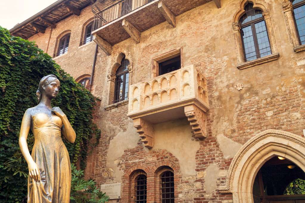 La casa de Julieta en Verona
Qué decir de este lugar, ícono máximo del amor en todas sus formas (incluidas las manifestaciones físicas). Cada año, miles de personas se pasean por este rincón de Italia para contemplar desde la calle el famoso balcón shakespeariano para hacer su particular homenaje a la interminable lucha entre los Capuleto y los Montesco.
Pero antes de visitar la célebre fachada, hay que acercarse a la Arena, un anfiteatro con más de 20 siglos de historia donde se celebran espectáculos y conciertos todo el año. Un verdadero placer que debe continuar con un paseo por la muralla hasta acabar en Castelvecchio.
