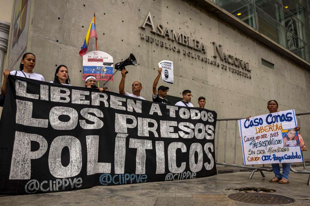 AME3935. CARACAS (VENEZUELA), 10/02/2026.- Personas sostienen carteles durante una manifestación este martes, frente a la Asamblea Nacional en Caracas (Venezuela). La Asamblea Nacional (AN, Parlamento) y el Programa para la Convivencia y la Paz de Venezuela aseguraron que seguirán recibiendo propuestas de familiares de presos políticos en el marco de las consultas públicas por el proyecto de ley de amnistía, propuesta por la presidenta encargada del país suramericano, Delcy Rodríguez. EFE/ Miguel Gutiérrez