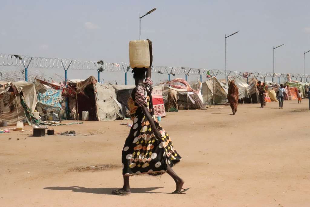 -FOTODELDÍA- RENK (SUDÁN DEL SUR), 17/05/2024.- Una mujer transporta sobre su cabeza una garrafa de agua que acaba de rellenar en una fuente en el centro de tránsito de Renk, en el norte de Sudán del Sur. El agua, un bien preciado ante los problemas que causa el estrés bélico en las infraestructuras sanitarias. EFE/Rosa Soto