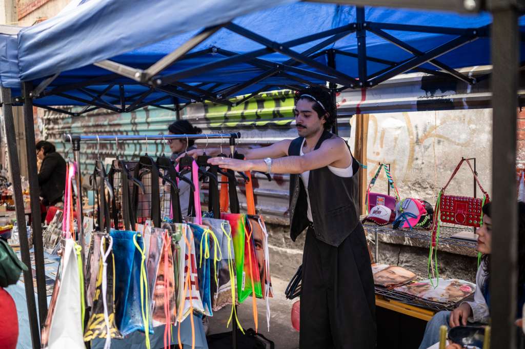 Mexican fashion designer Mizael Perea, 33, places bag designs made from election campaign poster materials at his stall in Lagunilla neighborhood, Mexico City, on June 30, 2024.