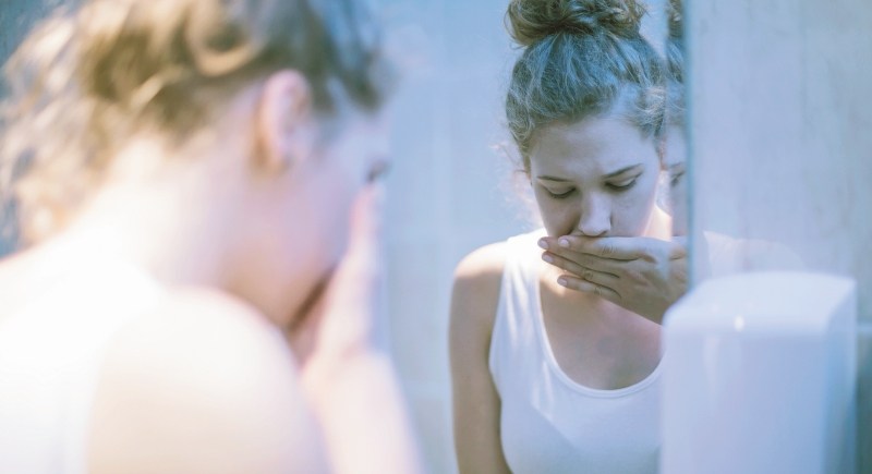 Worried girl standing in front of mirror