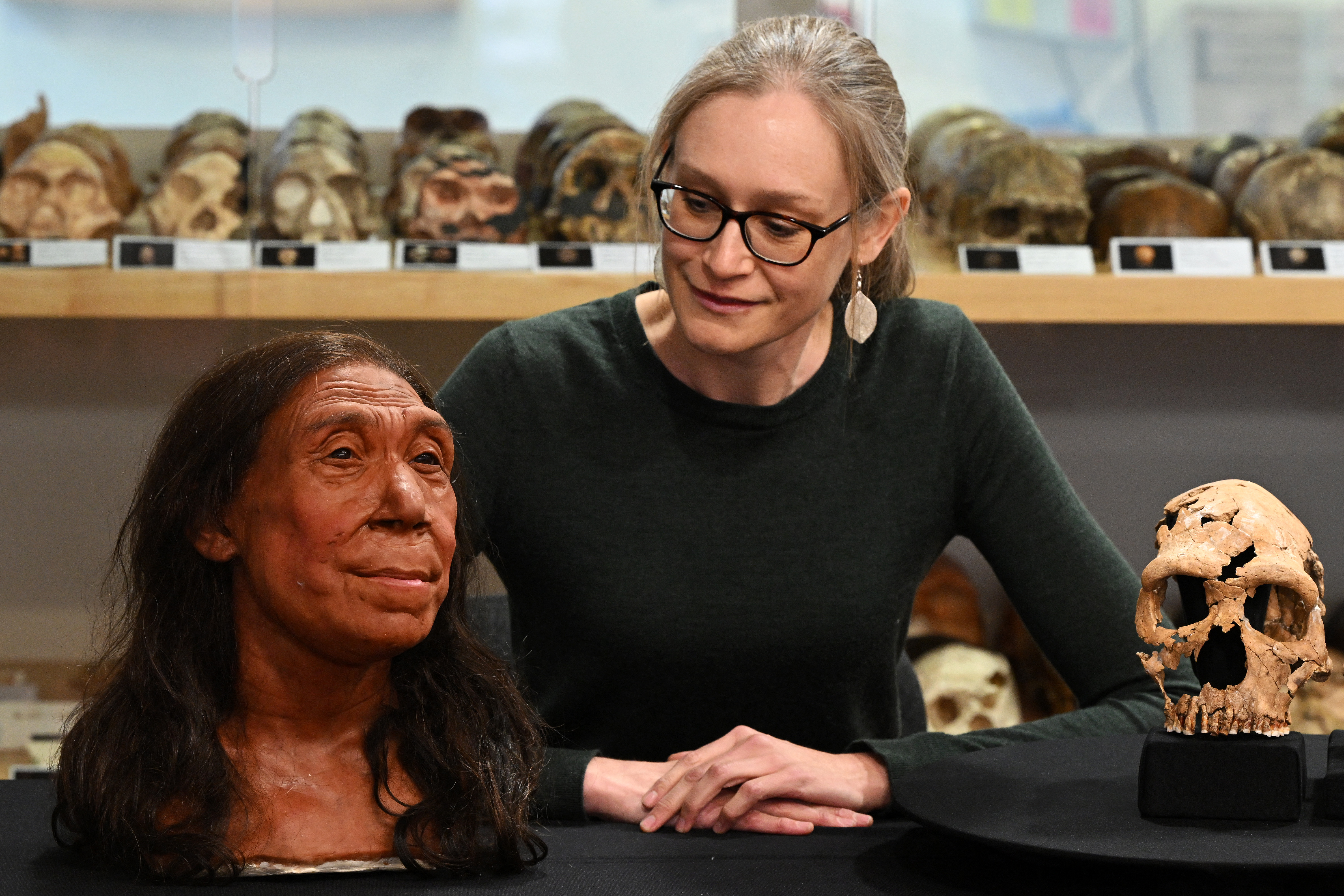 Associate Professor in the Evolution of Health, Diet and Disease, Dr Emma Pomeroy, poses for a photograph with the rebuilt skull and a physical reconstruction of the face and head, of a 75,000-year-old Neanderthal woman, named Shanidar Z, at the University of Cambridge, eastern England, on April 25, 2024.