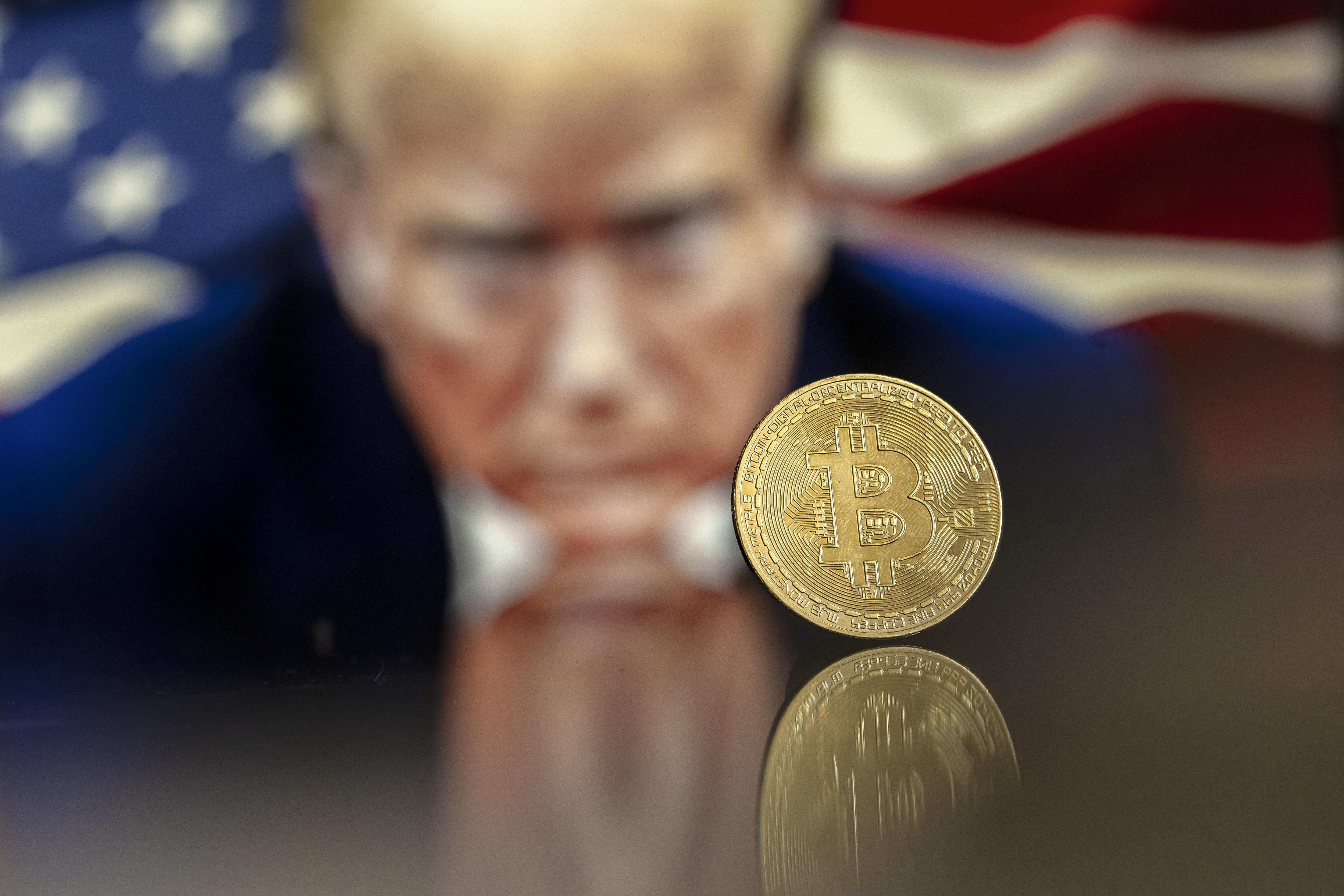 EA5586. BOGOTÁ (COLOMBIA), 05/12/2024.- Fotografía de archivo del 22 de noviembre del 2024 del símbolo de Bitcoin junto a una imagen del presidente electo de Estados Unidos, Donald Trump, en Lugano (Suiza). 'Un bitcóin viento en popa' es uno de los clics tecnológicos de la semana. Y es que el miércoles el bitcóin trepó la barrera de los 100.000 dólares, aupado por el entusiasmo de la elección de Donald Trump como presidente de Estados Unidos y la designación de Paul Atkins, un abogado abiertamente defensor de las criptomonedas, como futuro presidente de la Comisión de Bolsa y Valores (SEC), el principal organismo regulador de EE.UU. EFE/EPA/PABLO GIANINAZZI / ARCHIVO