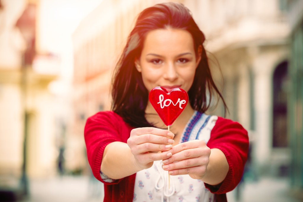 Girl with a lollipop in the shape of heart on the promenade. Estos son los 4 signos zodiacales más dulces
