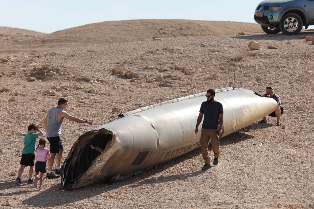 Negev (Israel), 02/10/2024.- People look at the wreckage of an Iranian ballistic missile in the Negev desert near the Dead Sea, southern Israel, 02 October 2024. According to the Israeli military, Iran launched over 180 ballistic missiles towards Israel in the evening of 01 October, with alert sirens sounding across the country. EFE/EPA/ABIR SULTAN