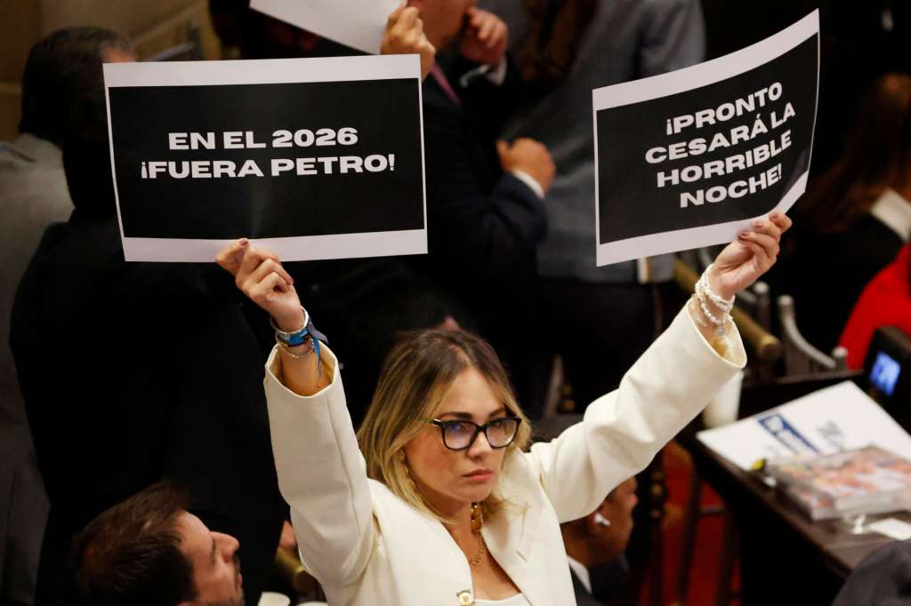 AME4160. BOGOTÁ (COLOMBIA), 20/07/2025.- Una mujer sostiene carteles en contra del presidente de Colombia, Gustavo Petro, durante la instalación del nuevo periodo de sesiones del Congreso este domingo, en Bogotá (Colombia). Petro destacó ante el Congreso los avances económicos que ha conseguido en sus primeros tres años de Gobierno pero reconoció que no ha logrado sacar adelante la política de "paz total" con los grupos armados, una de sus grandes promesas de campaña. EFE/ Mauricio Dueñas Castañeda