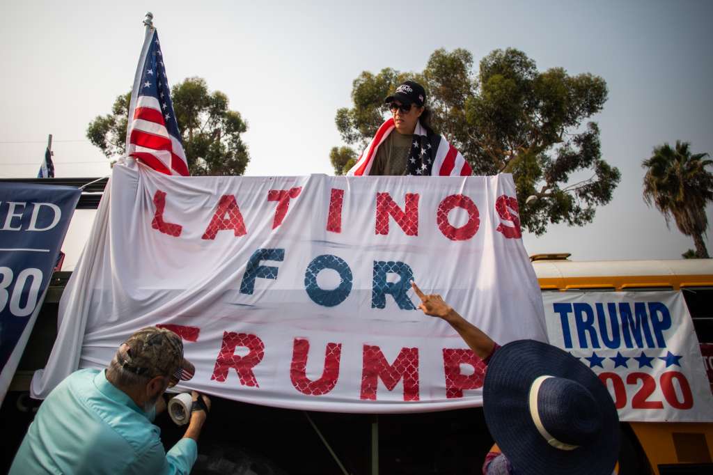 La gente decora un camión con una pancarta que dice "Latinos por Trump" durante una caravana de autos Pro-Trump en Ventura Blvd en Studio City, un vecindario de la ciudad de Los Ángeles, el 13 de septiembre de 2020, en medio de la pandemia de coronavirus.