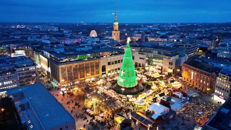 DORTMUND (Germany), 05/12/2025.- An areal view shows the city's Christmas tree which is illuminated at the Christmas market in Dortmund, Germany, 05 December 2025. The 45-meter-high Christmas tree is made of 1,700 fir trees and decorated with 48,000 LED lights. (Alemania) EFE/EPA/CHRISTOPHER NEUNDORF