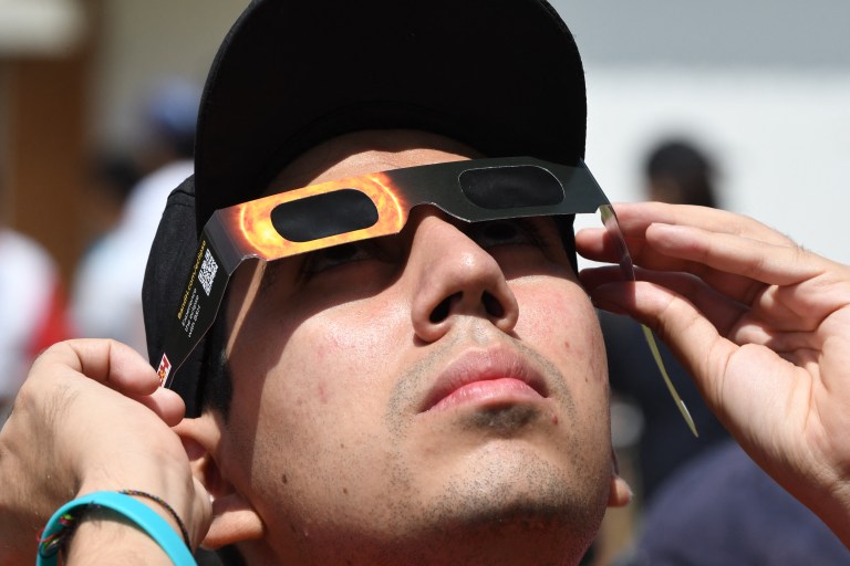 Una persona observando el eclipse con la debida protección a sus ojos.