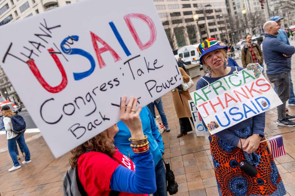 WASHINGTON (United States), 27/02/2025.- Holly Fletcher joins former employees of the United States Agency for International Development (USAID) and supporters during a rally outside the headquarters as workers terminated or placed on leave retrieve their personal belongings in Washington, DC, USA, 27 February 2025. USAID workers who were fired or placed on leave have been given 15 minutes to retrieve personal belongings from their former offices. (Estados Unidos) EFE/EPA/SHAWN THEW