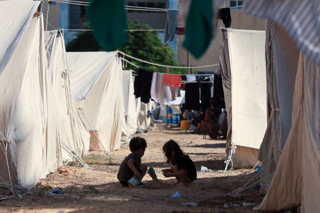 Niños juegan entre tiendas de campaña instaladas para los palestinos que buscan refugio en los terrenos de un centro de la Agencia de Obras Públicas y Socorro de las Naciones Unidas para los Refugiados de Palestina (OOPS), en el sur de la Franja de Gaza.