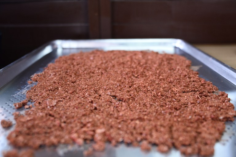 La carne, luego de ser molida, se dispone en unas bandejas, para luego llevarlas a un horno y culminar el proceso de transformación.