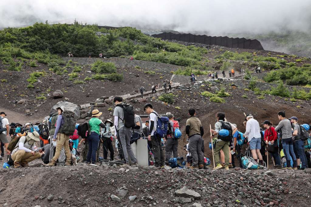 (FILES) This file photo taken on August 31, 2023 shows visitors climbing the slopes of Mount Fuji, Japan's highest peak at 3,776 meters (12,388 feet).