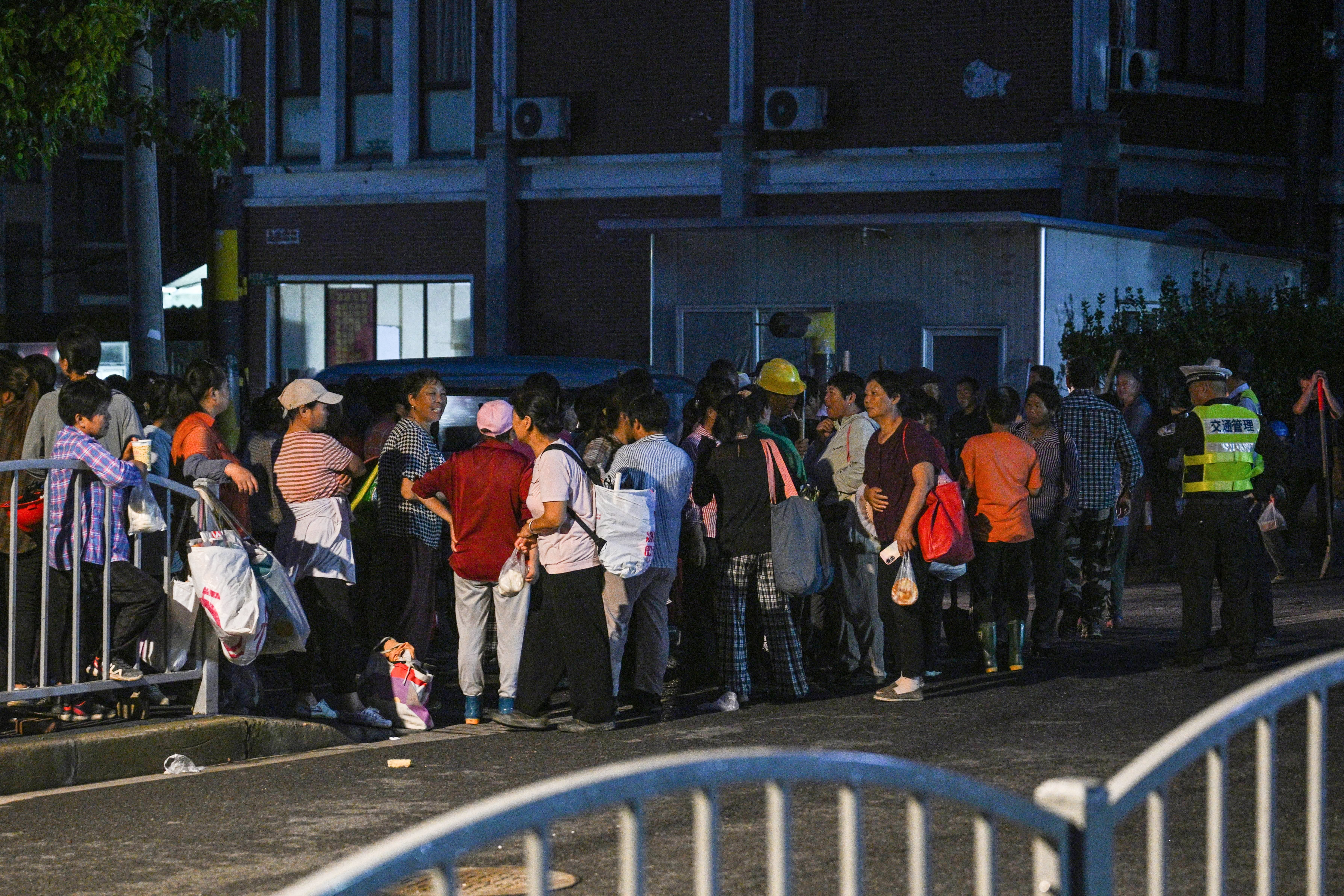 People looking for employment gather at an informal roadside labour exchange in Shanghai on July 11, 2024.