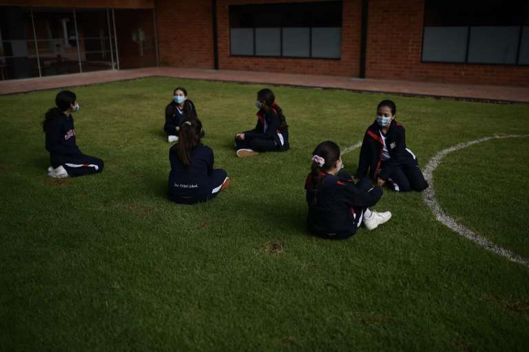 Niños sentados en el patio de recreo.