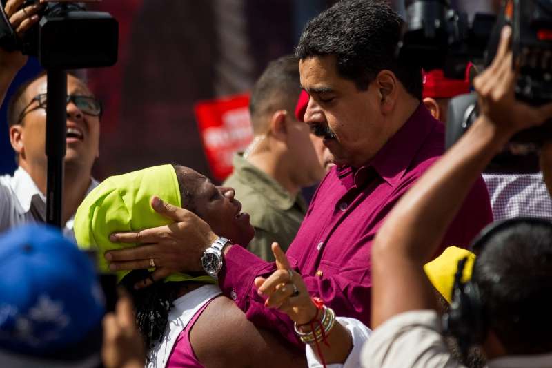 El presidente de Venezuela, Nicolás Maduro (d), saluda a una seguidora en Caracas. / EFE