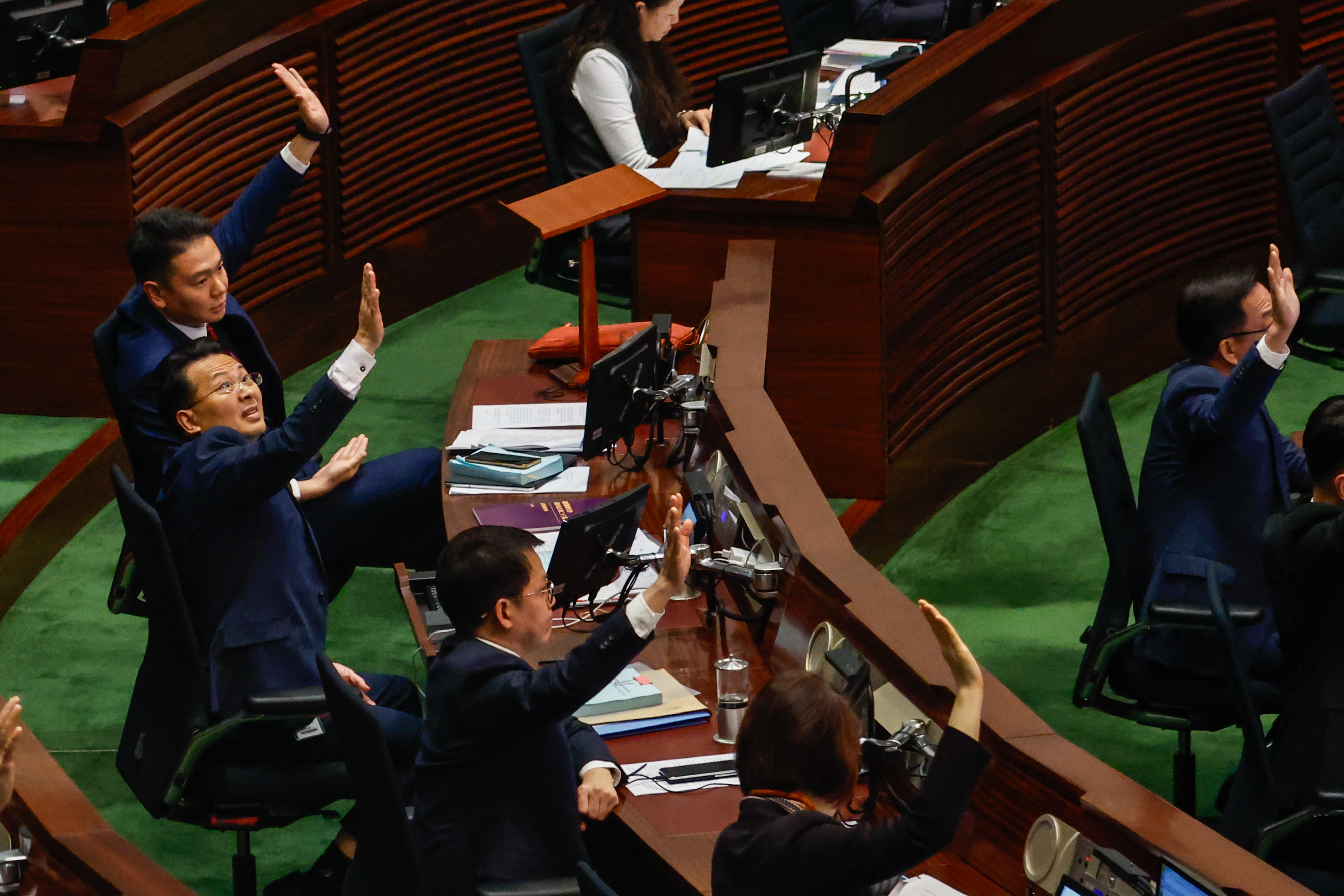 Hong Kong (China), 19/03/2024.- Lawmakers raise their hands to vote for law amendments related to the Article 23 at the Legislative Council, in Hong Kong, China, 19 March 2024. Article 23, required by a Beijing-imposed National Security Law, has sparked international concerns about its impact on press freedom, religious freedom, and fundamental rights. Foreign governments such as the United Kingdom, the United States, Australia, and some European countries have also expressed concerns over the legislation. (Reino Unido, Estados Unidos) EFE/EPA/DANIEL CENG