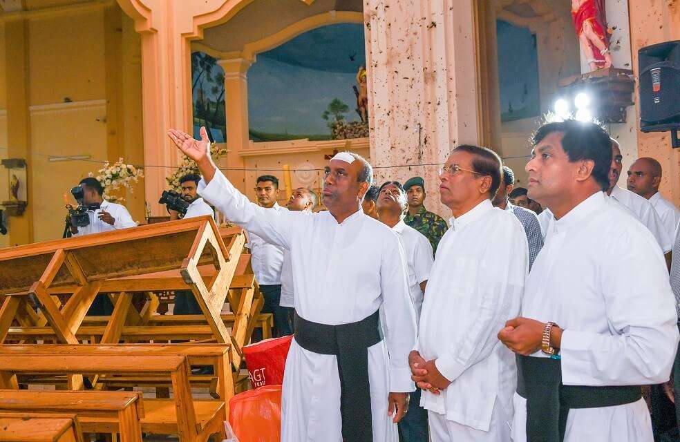 El presidente de Sri Lanka, Maithripala Sirisena (c) visitó la iglesia de San Sebastián, en Negombo, dos días después de que fuera bombardeada. / AFP