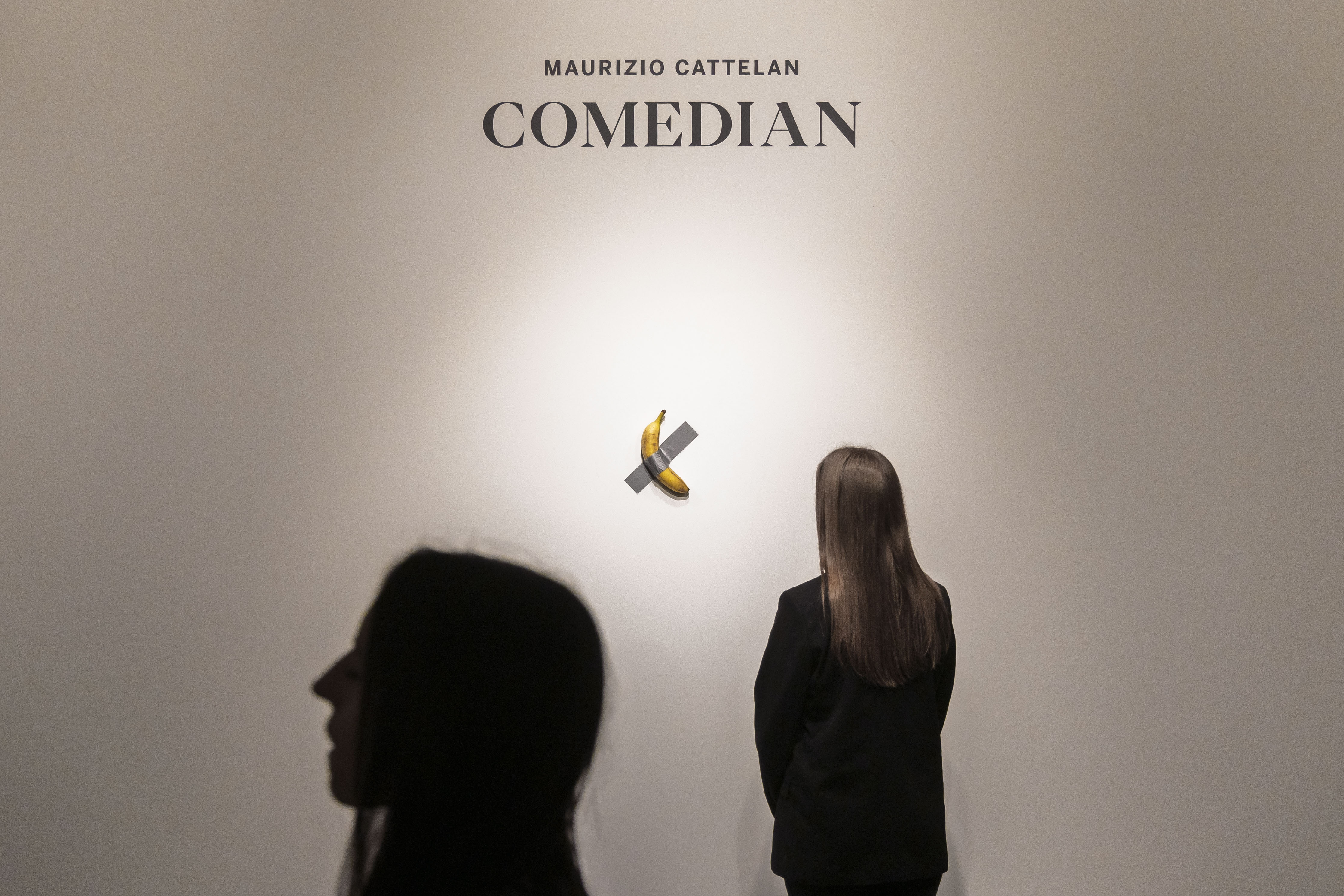 New York (United States), 25/10/2024.- A person looks at Italian artist Maurizio Cattelan's 'Comedian,' a conceptual art piece of a real banana attached to a wall with duct tape, during a press preview for an upcoming auction of the work at Sotheby's auction house in New York, New York, USA, 25 October 2024. The piece is estimated to sell for 1 million - 1.5 million USD (925,000 - 1.4 million EUR) during an auction in November. (Nueva York) EFE/EPA/JUSTIN LANE