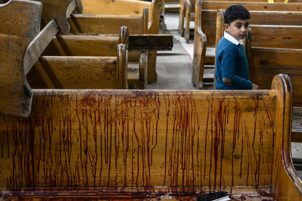 Un niño pasa al lado de una banca en la iglesia Mar Girgis en Tanta tras el atentado. / EFE