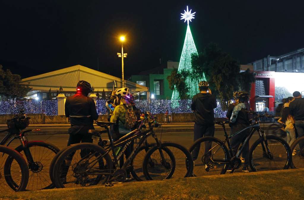 AME5143. BOGOTÁ (COLOMBIA), 12/12/2024.- Ciclistas observan decoración navideña este jueves, durante una jornada de ciclovía nocturna en Bogotá (Colombia). Los bogotanos podrán recorrer más de los 90 kilómetros de vías habilitadas y disfrutar el alumbrado navideño y actividades recreativas en puntos estratégicos EFE/ Mauricio Dueñas Castañeda