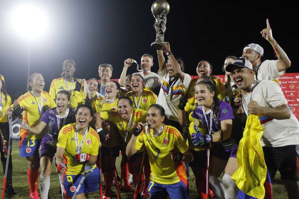 Las jugadoras de la selección de Colombia, junto a Kelis Peluzine (cent.), que alza el trofeo.
