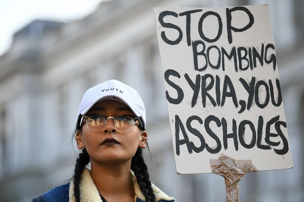 Una manifestante protesta contra la decisión de Donald Trump de bombardear una base aérea en Siria el viernes en la madrugada. / AFP