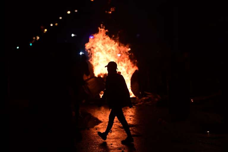 La silueta de un hombre frente a una gran llamarada.