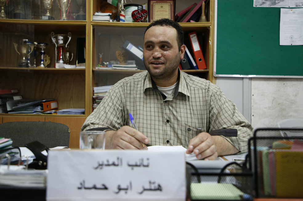 Hitler Abu Hamad, subdirector de una escuela, se sienta en su oficina en la ciudad ocupada de Hebrón, Israel.  / AFP