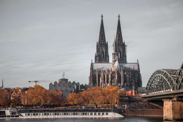 La Catedral de Colonia es uno de los templos góticos más imponentes de Europa y símbolo de la ciudad de Colonia, Alemania a orillas del Rin. Su construcción comenzó en 1248 y se extendió por más de seis siglos, culminando en 1880 con sus icónicas torres de 157 metros que dominan el paisaje. Famosa por albergar las reliquias de los Reyes Magos, se convirtió en un importante centro de peregrinación, y hoy destaca por su arquitectura, sus vitrales y su valor histórico, reconocido como Patrimonio de la Humanidad por la UNESCO desde 1996.