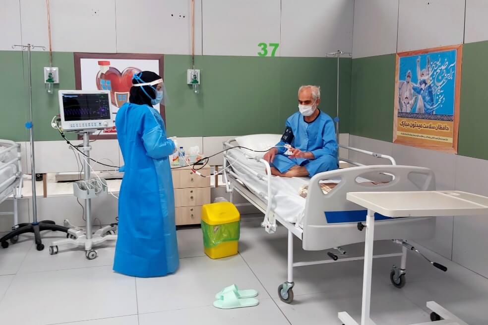 Una enfermera atiende a un enfermo de coronavirus en un hospital montado en un centro comercial en Irán. / EFE