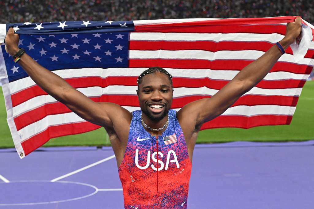 TOPSHOT - US' Noah Lyles (C) celebrates after winning the men's 100m final of the athletics event at the Paris 2024 Olympic Games at Stade de France in Saint-Denis, north of Paris, on August 4, 2024. (Photo by Andrej ISAKOVIC / AFP)
