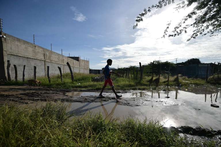 Un niño caminando sobre agua estancada