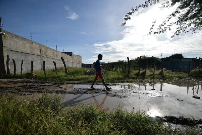 Un niño caminando sobre agua estancada