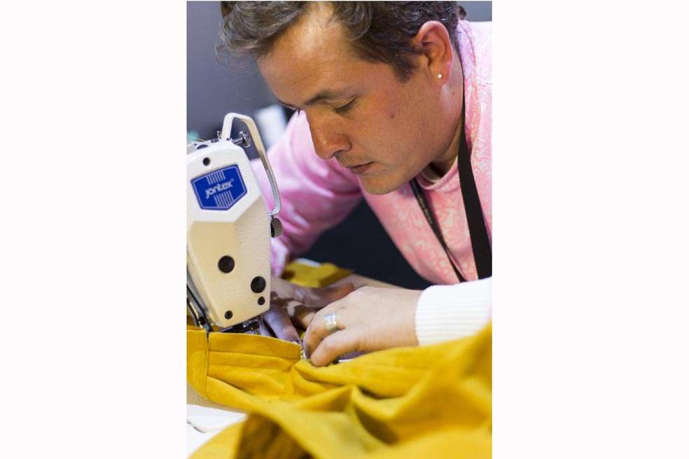 Jorge Duque sentado ante una de sus máquinas de coser, una actividad que practica varias horas al día y que combina con la búsqueda de materiales. / Archivo particular