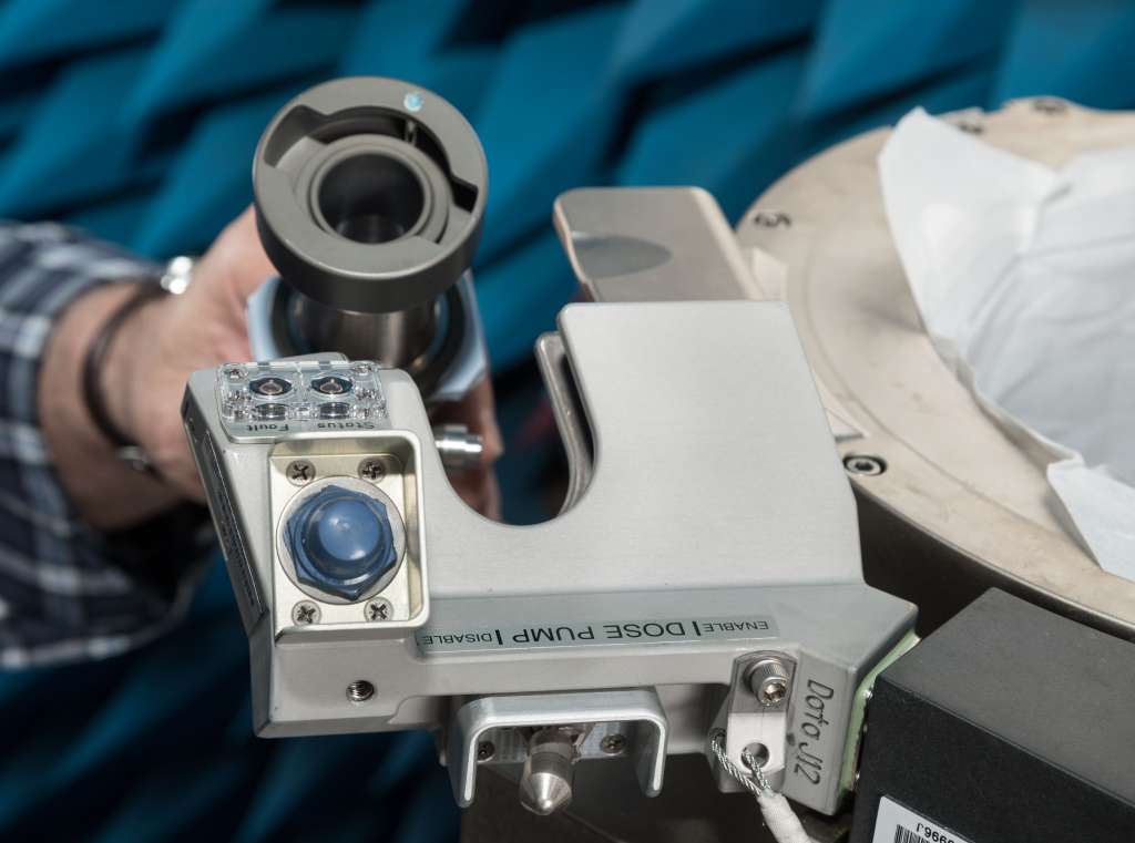 Un miembro del equipo de la Nasa levanta la manguera de orina de su posición acunada como lo haría un miembro del equipo. Se adjunta un embudo (no se muestra) al extremo abierto de esta manguera y luego se puede reemplazar o quitar fácilmente para desinfectar.