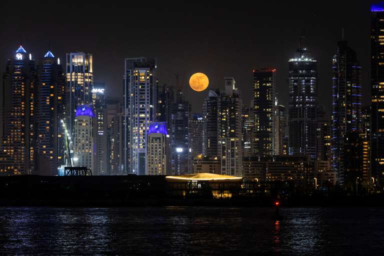 La luna llena, conocida como la «Luna de fresa», se eleva sobre el horizonte de Dubai el 11 de junio de 2025.