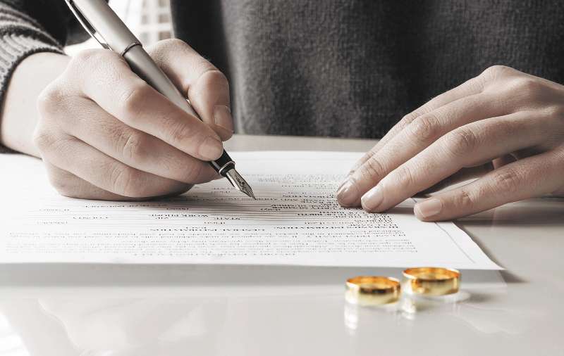 Wife signs divorce decree form with ring
