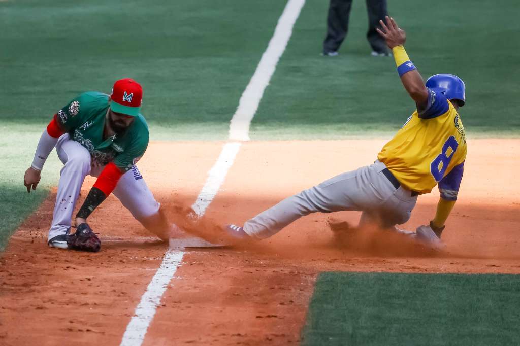 CARACAS (VENEZUELA), 10/02/2023.- Orlando Pina (i) de Cañeros de Mochis atrapa una pelota en tercera base frente Fabián Pertuz de los Vaqueros de Montería de Colombia hoy, en el partido por el tercer lugar de la Serie del Caribe 2023 en el estadio Monumental de Caracas Simón Bolívar en Caracas (Venezuela). EFE/ Miguel Gutiérrez
