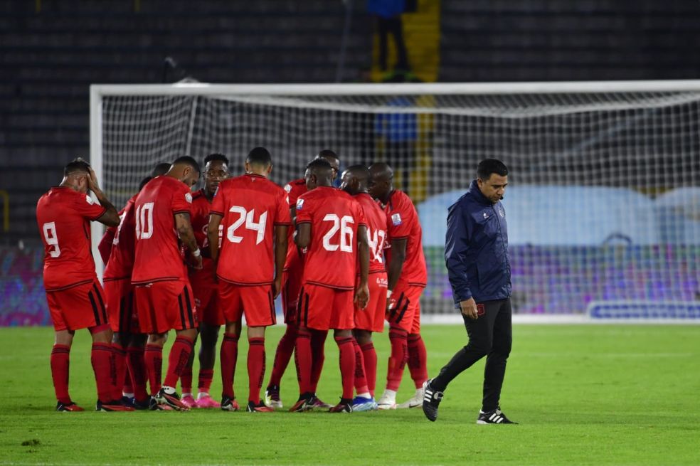 Los jugadores de América se quedan en la cancha tras la derrota, mientras su entrenador, César Farías, se marcha a los camerinos.