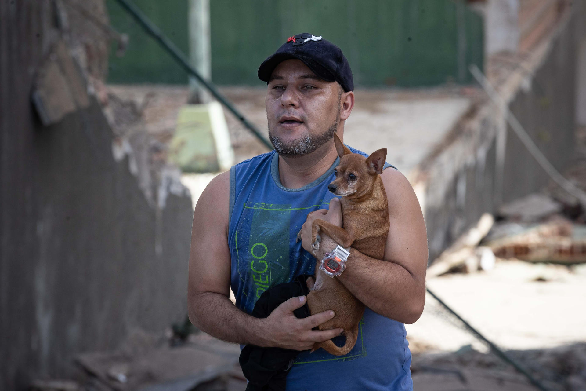 AME4382. CATIA LA MAR (VENEZUELA), 25/06/2026.- Una persona carga una mascota este jueves, en Catia La Mar (Venezuela). El número de fallecidos en Venezuela a causa de los dos terremotos del miércoles se elevó a 188 y el de heridos a 1.520, mientras que al menos 346 construcciones, entre edificios, hospitales y centros comerciales, resultaron afectadas, informó el presidente de la Asamblea Nacional (AN, Parlamento), el chavista Jorge Rodríguez. EFE/ Ronald Peña R.
